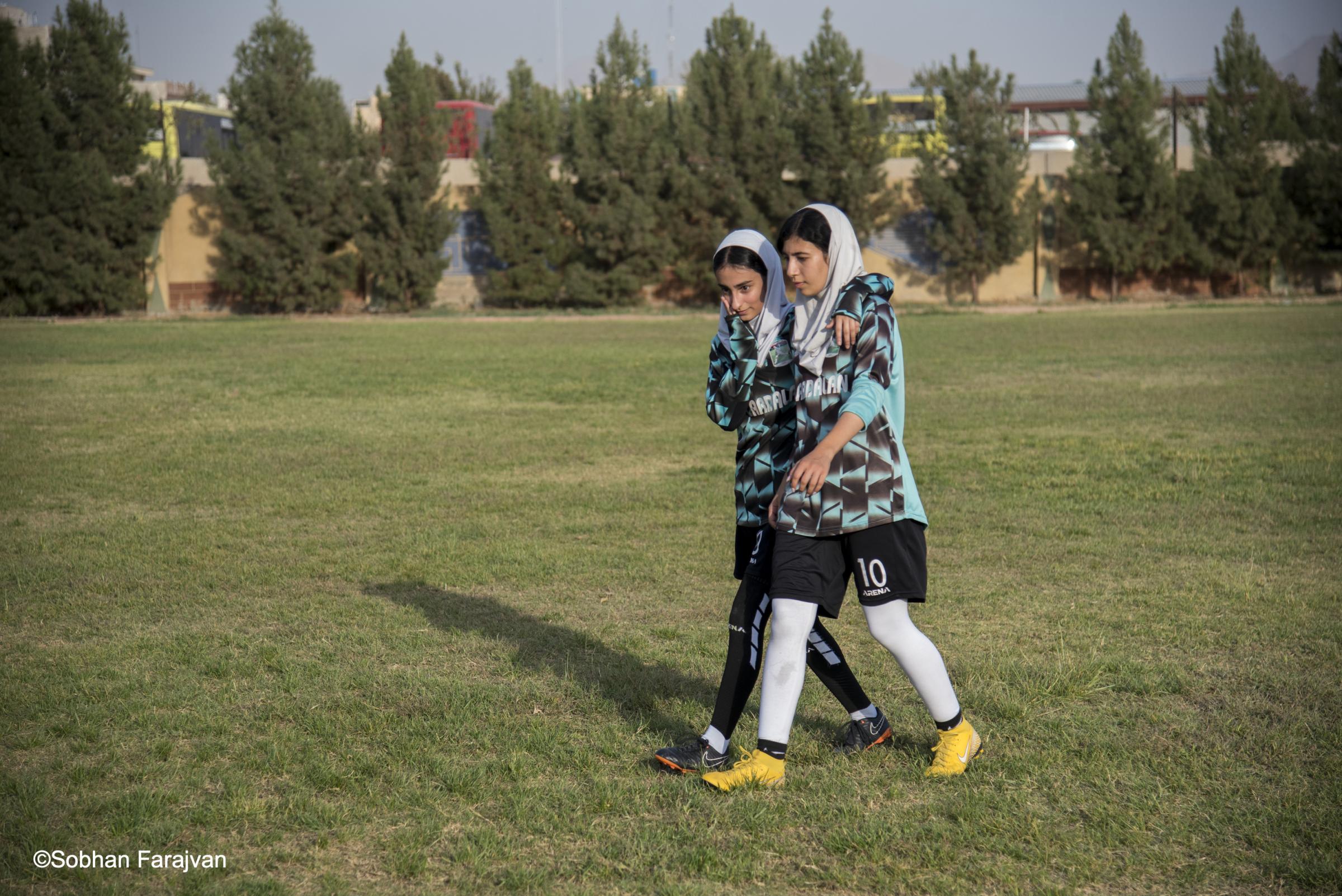 Iranian women's soccer academy (2022) - Two Iranian soccer players talk to each other during a...