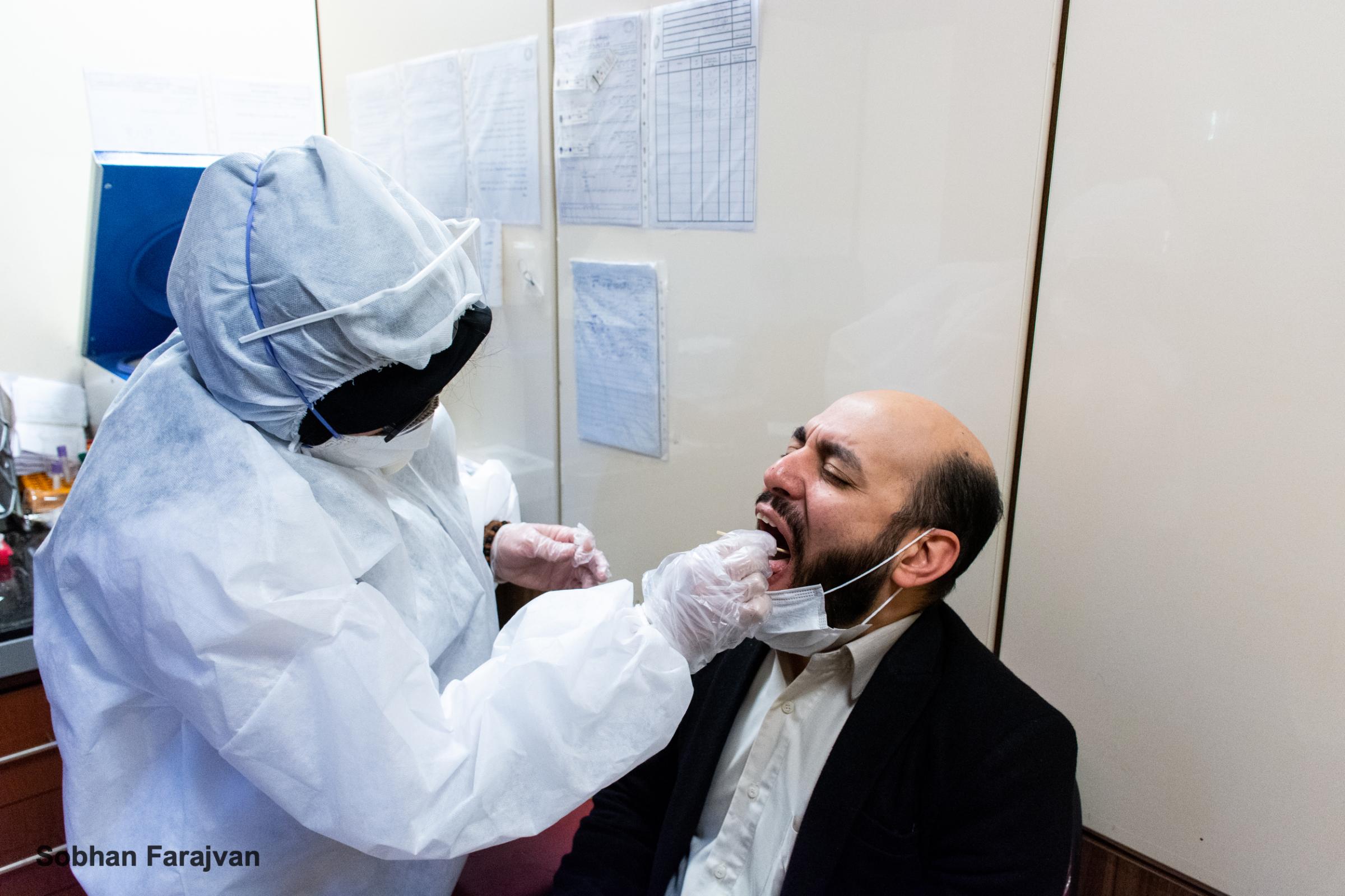 COVID-19 pandemic in Iran (2020-2022) - A laboratory technician wearing a protective suit is...