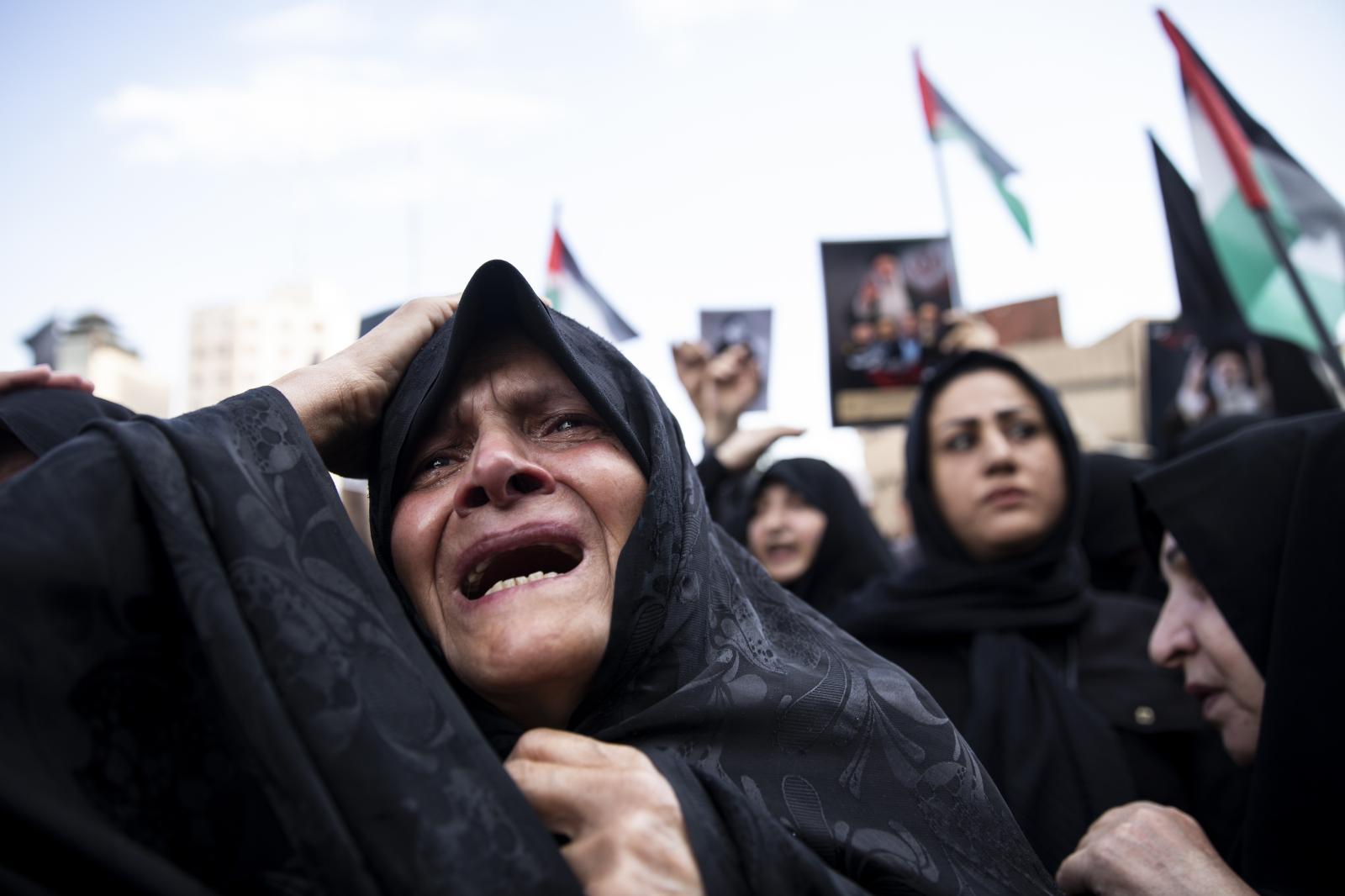 A woman weeps during a mourning...heir helicopter crashed in fog.
