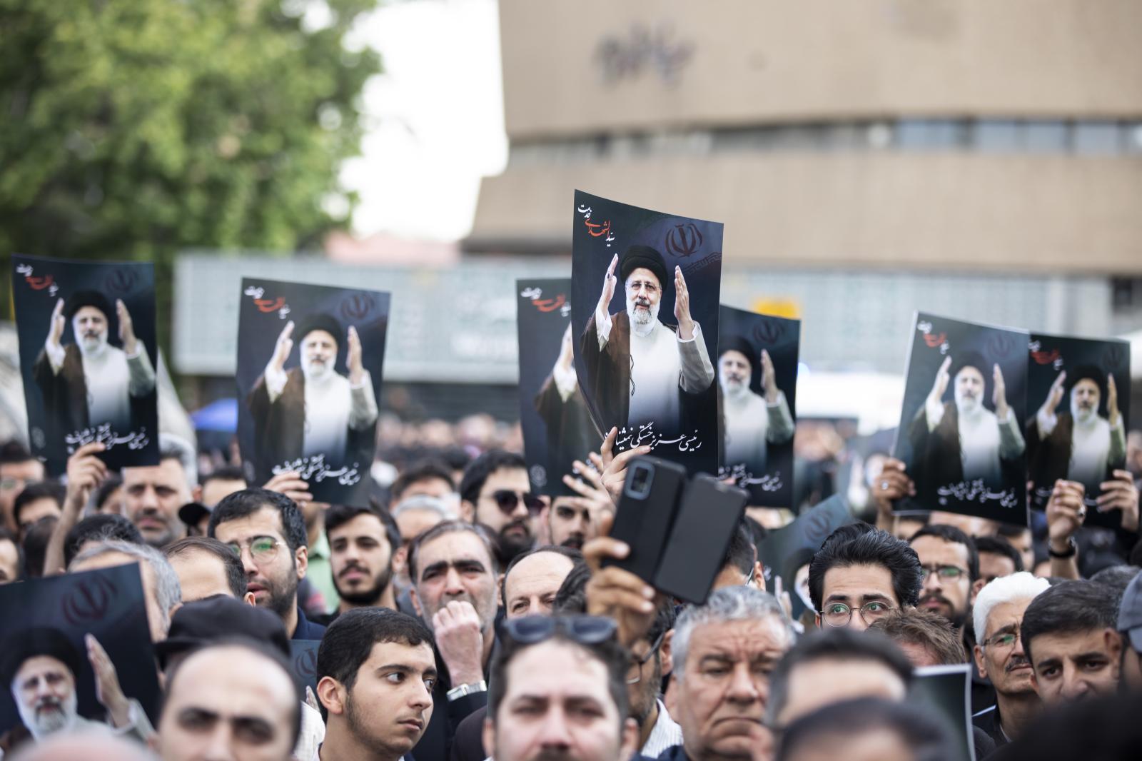 Iranian people hold up posters ...heir helicopter crashed in fog.