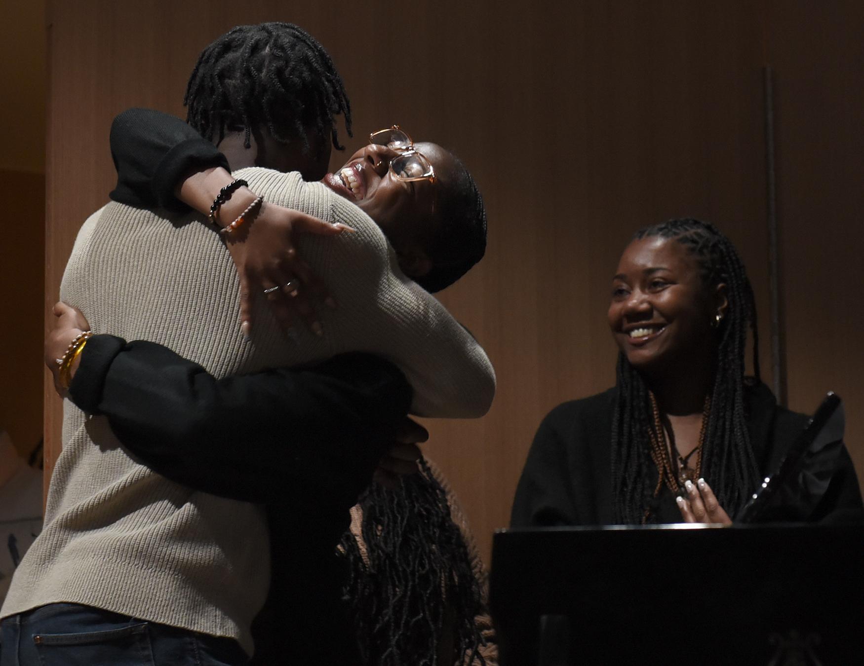  Lauryn Cummings, right, watches Brandon Gregory Jr. hug Bailey Sims, center, after she sang at Zou Soul on Monday, Oct. 17, 2022, at the...
