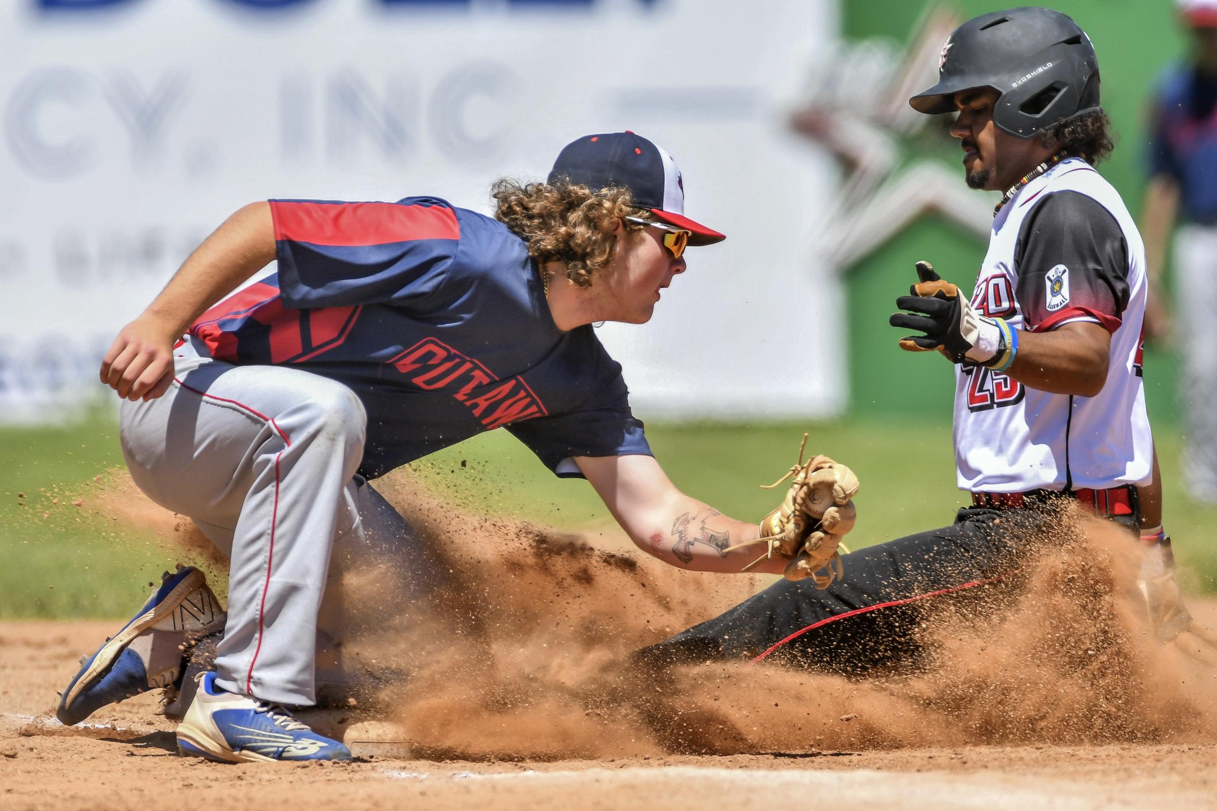 Singles - Post 320 player Gavyn Dansby slides into third base as an...