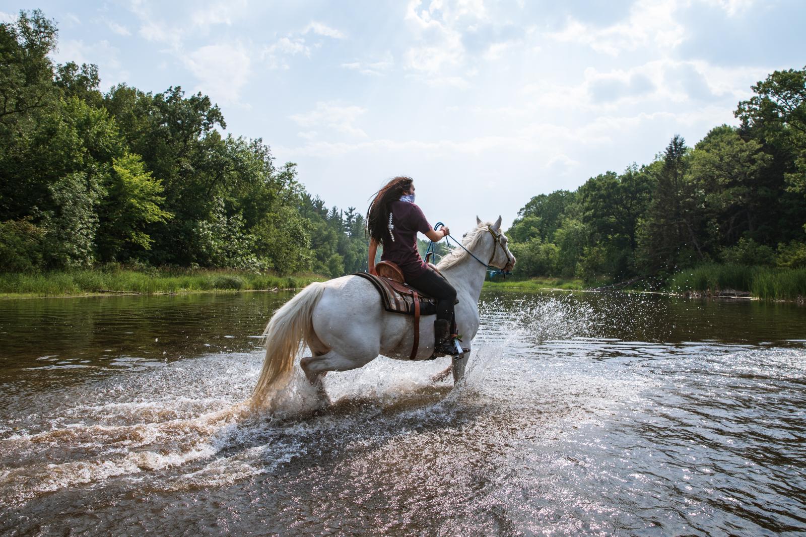 Kiley Knowles rides her horse t...Chris Trinh. Anishinaabe Akiing