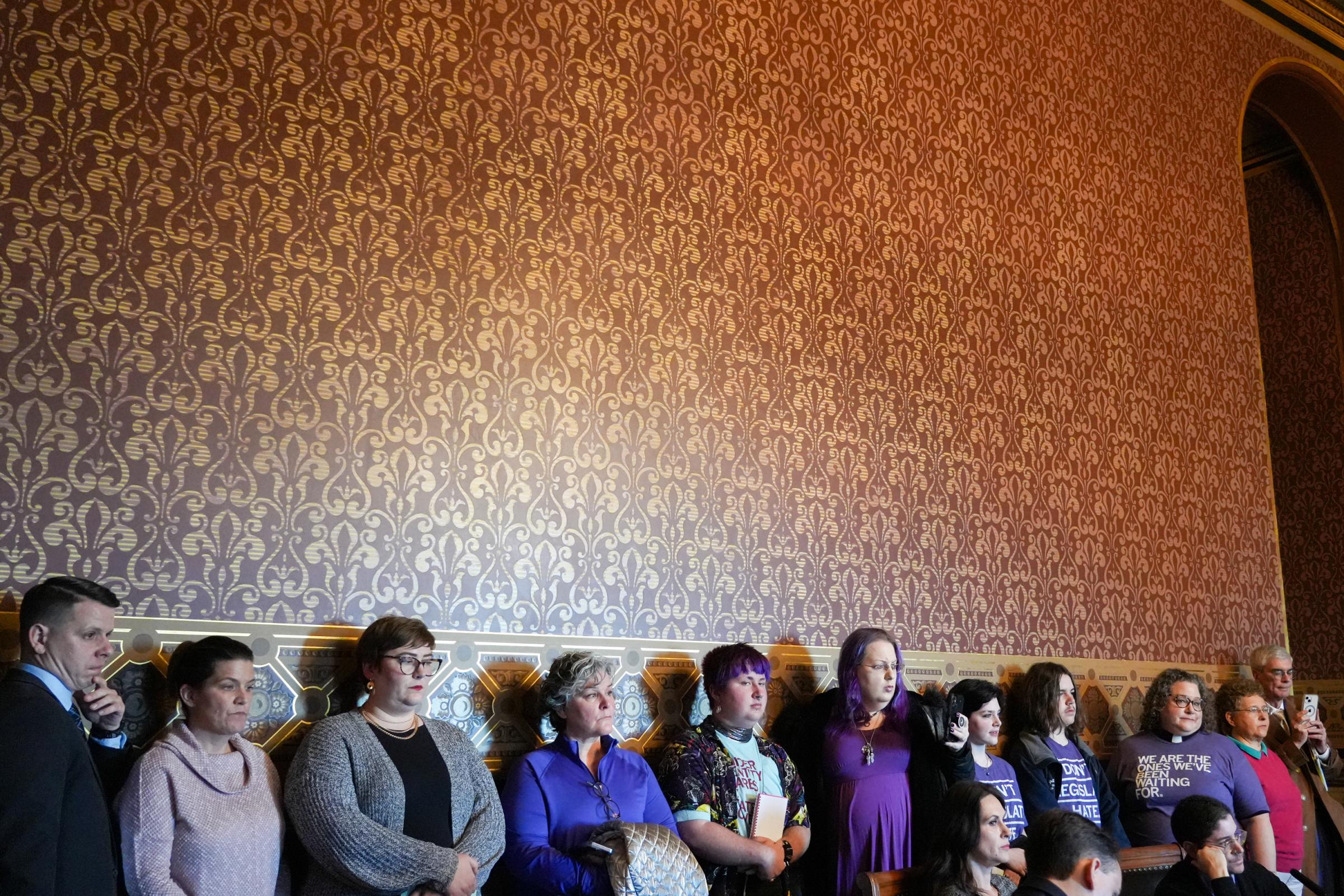 Singles - Iowans line up against the wall as they wait for their...