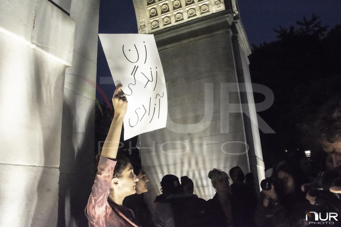 A protesters holds up a sign th...wearing the headscarf properly.