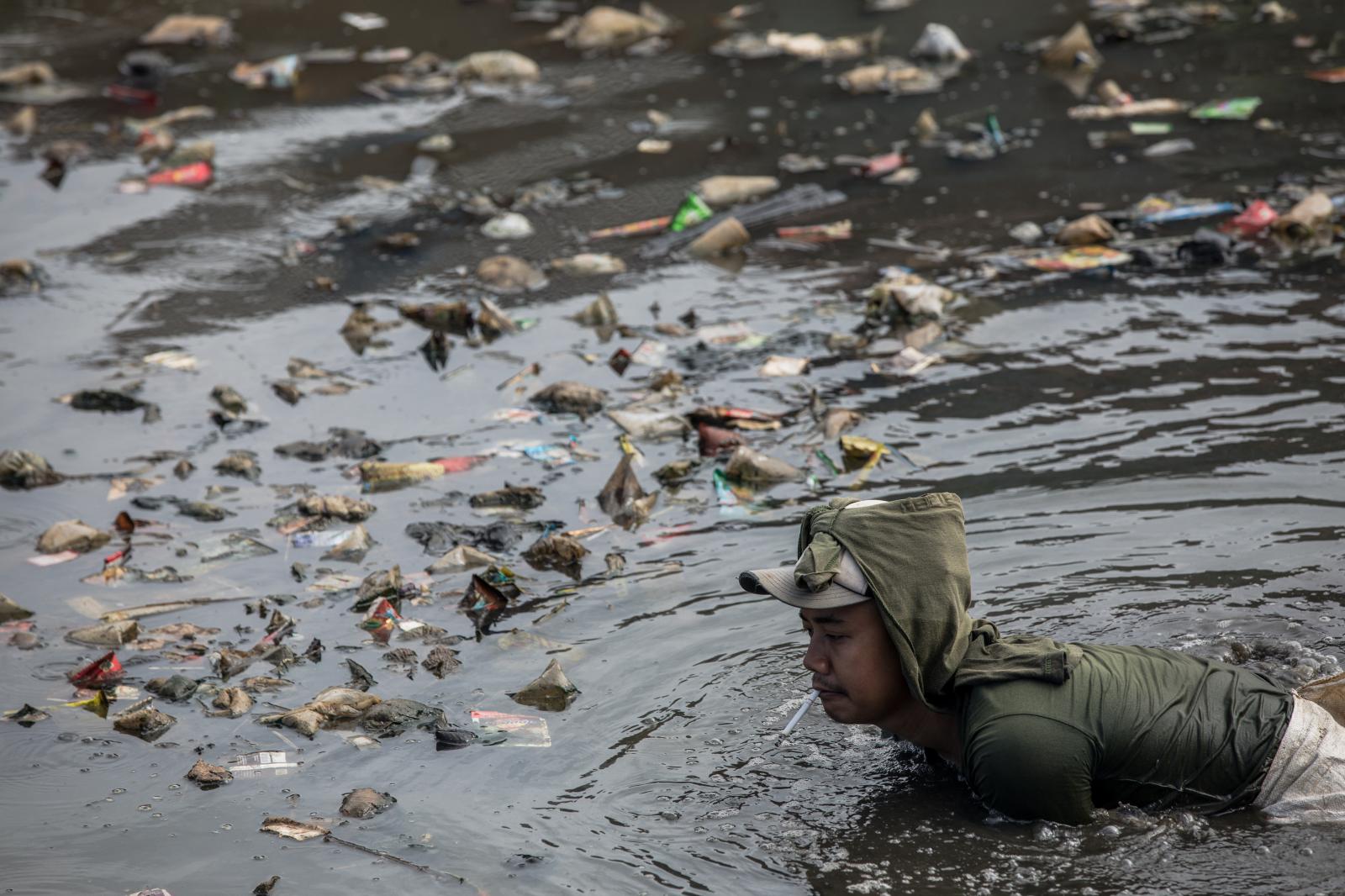 A man working at a polluted canal in Bogor, West Java, Indonesia.