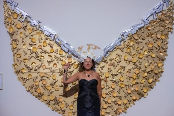 Image from SomArts - Alicia Cruz poses in front of her art piece, Ximoquetza...