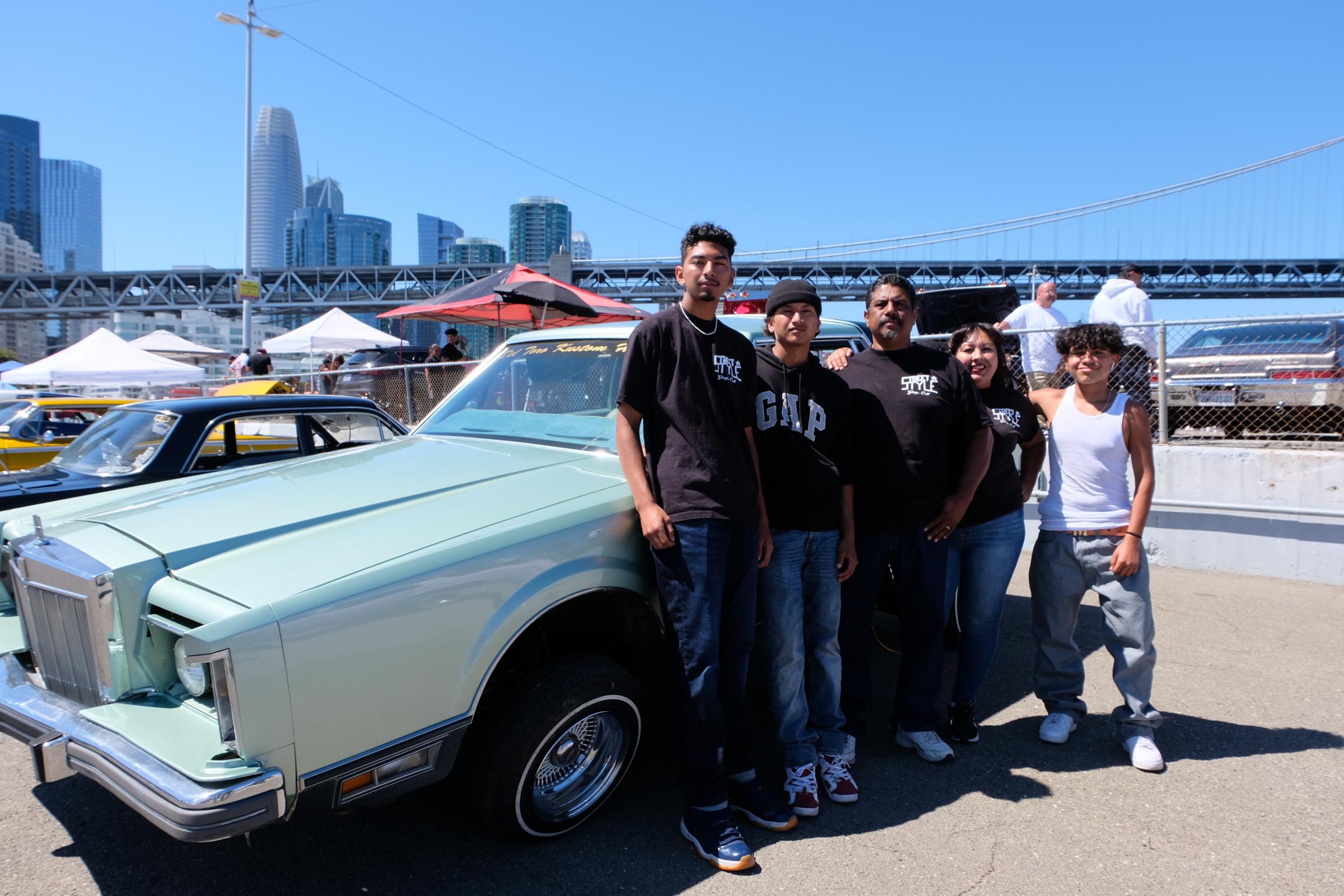 Lowriders Show: King of the Streets - Del Toro's family poses in front of one of the cars...