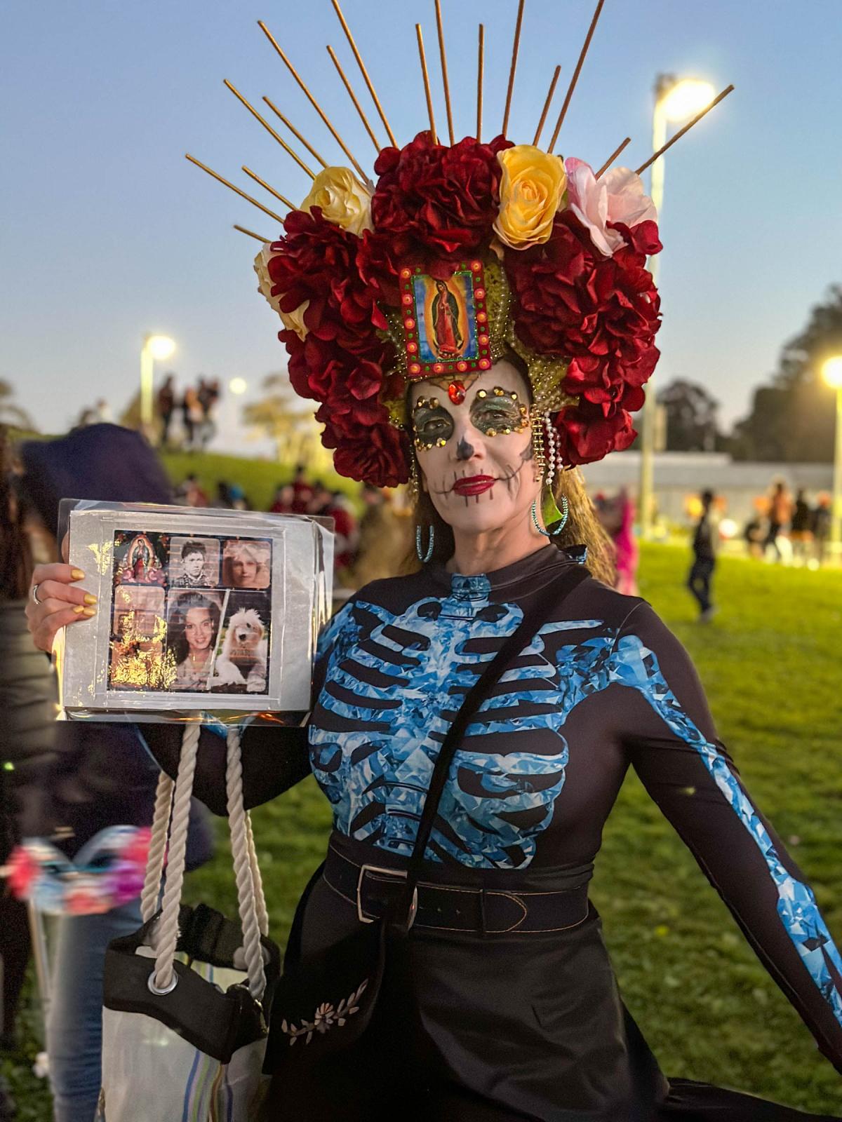 Day of the Dead Celebration - Nancy, dressed as Catrina, shows the photos of her loved...