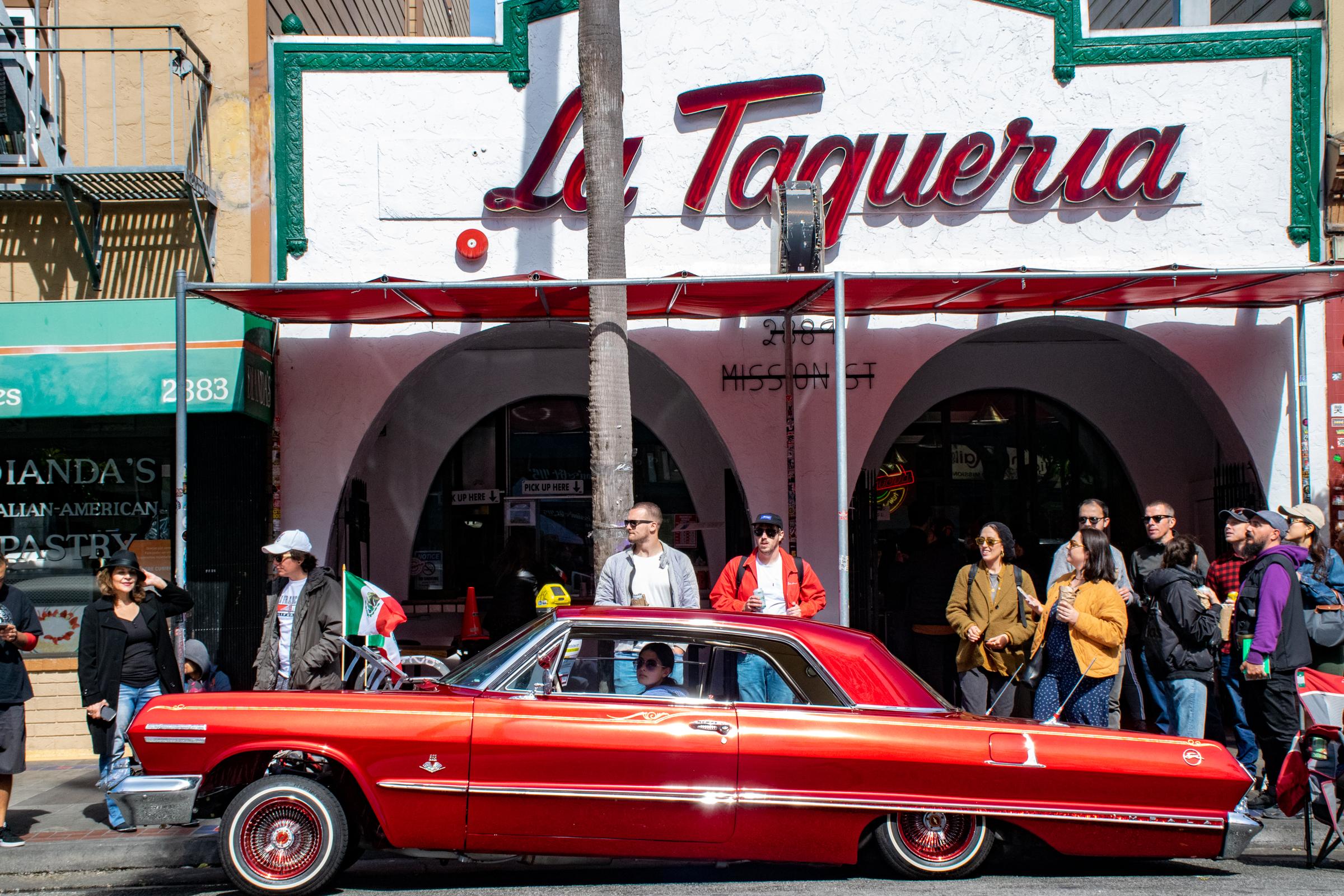 Lowriders Cinco de Mayo Show -  A red lowrider is parked in front of La Taqueria on...