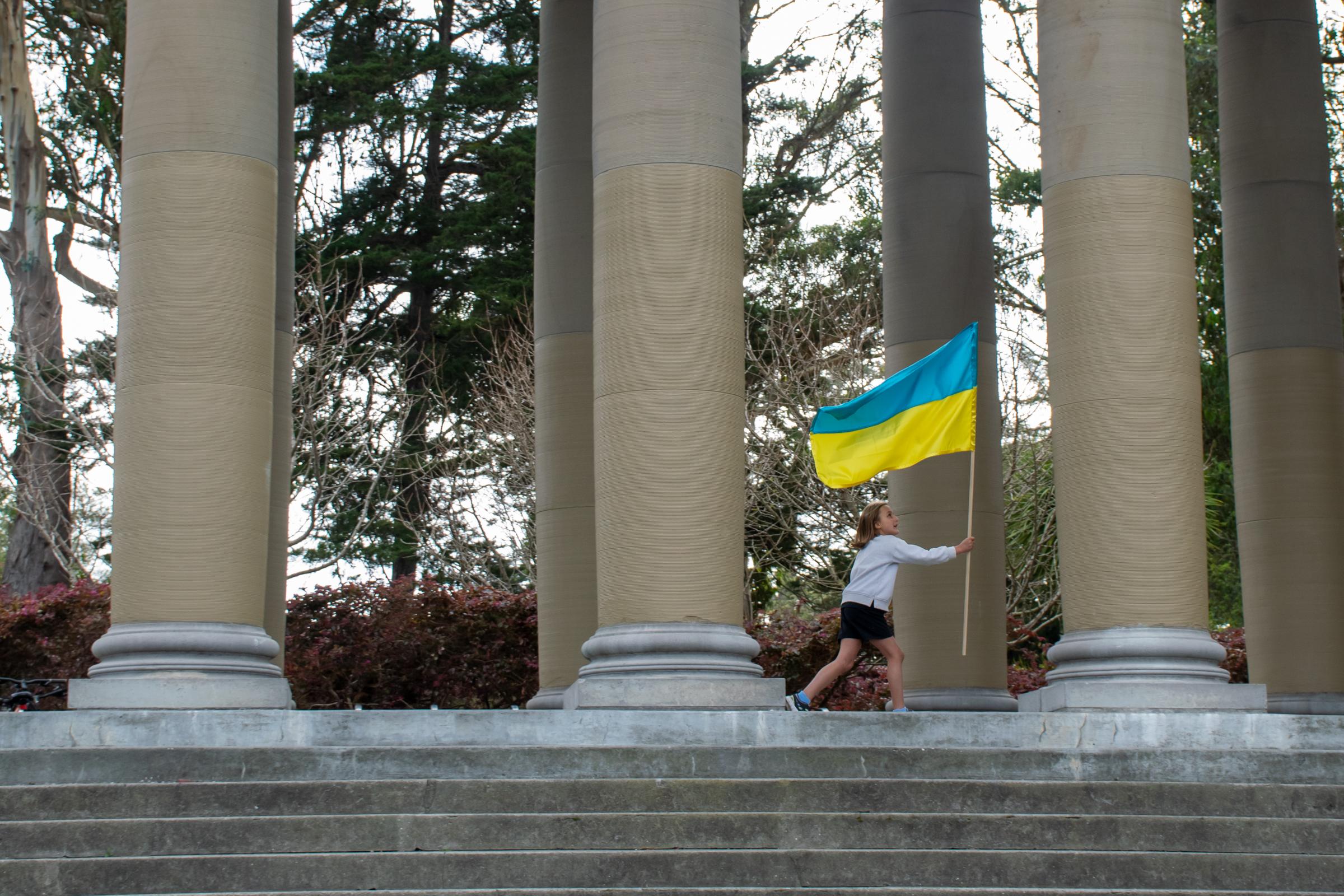 Concert for Ukraine -  A kid walks through the Golden Gate Bandshell holding up...