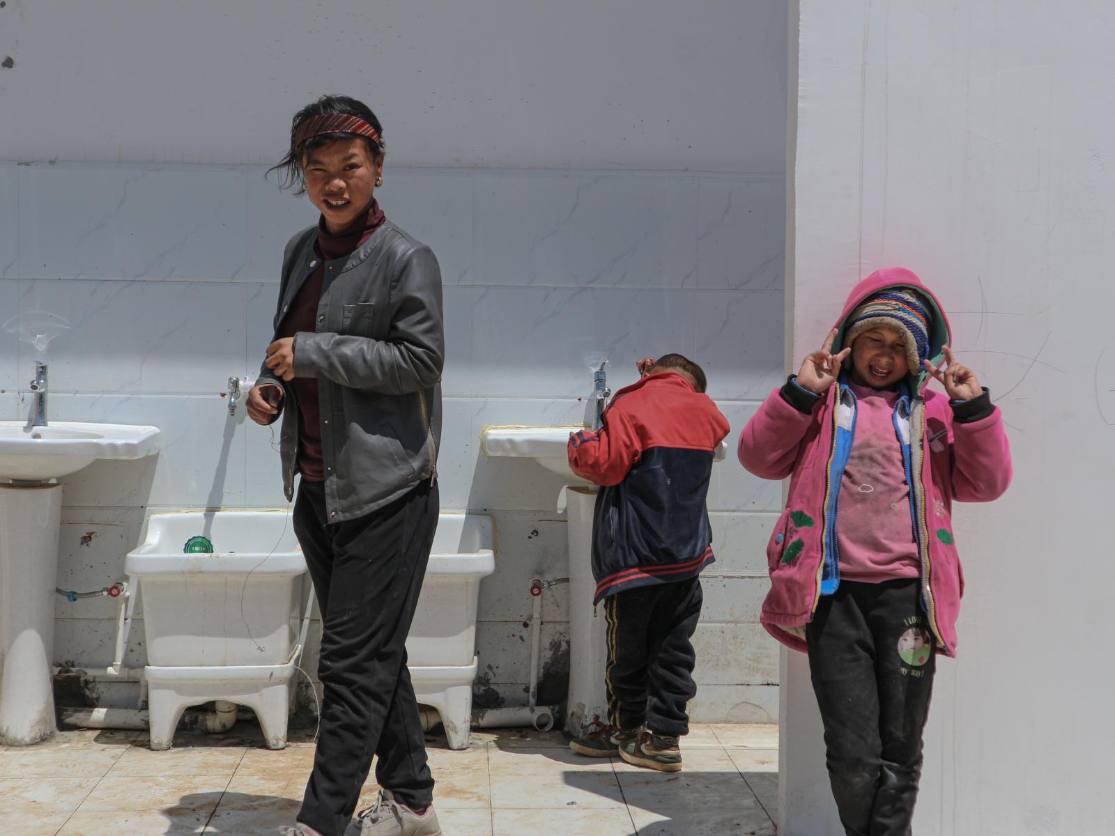 Image from Streets - Yi kids stood in front of the newly built restroom in...