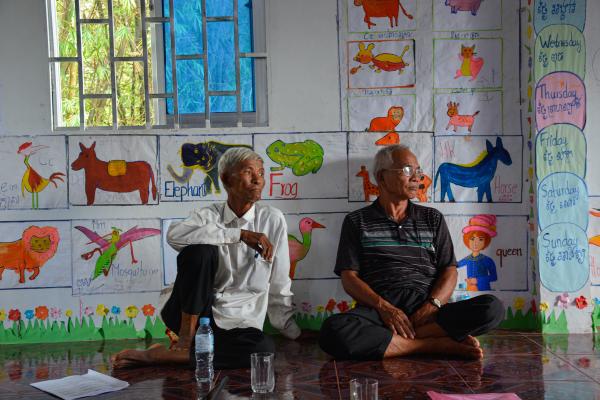 Image from Revisiting Khmer Rouge - Villagers sit at the community center, waiting for the...