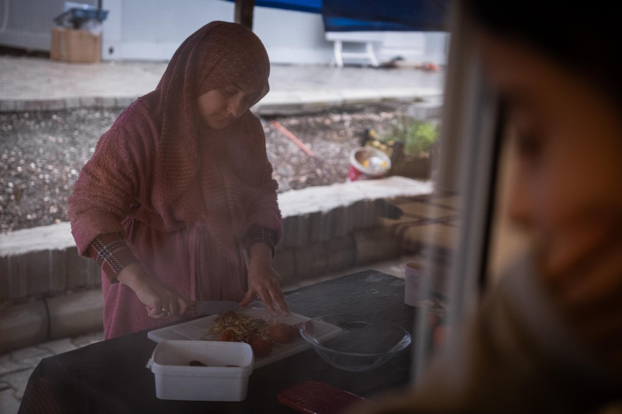 One year on, the ancient city of Antakya struggles to show its first signs of life -  Sevcan daughter observes her mother cooking from inside their new container. Despite containers...