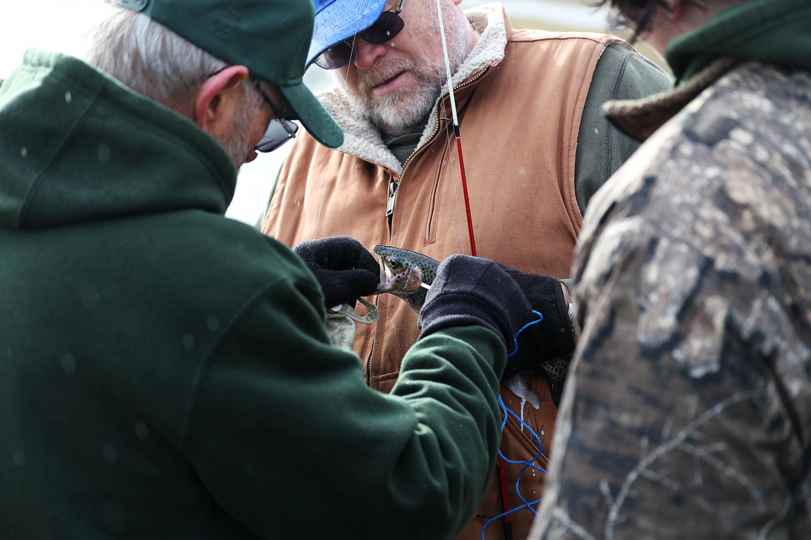 Image from Moments - Fisherman Ron Otto holds a trout after catching it at...