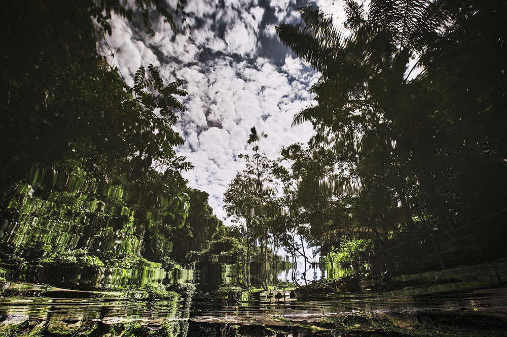  A sky reflection of the forest in a hot water pool 
