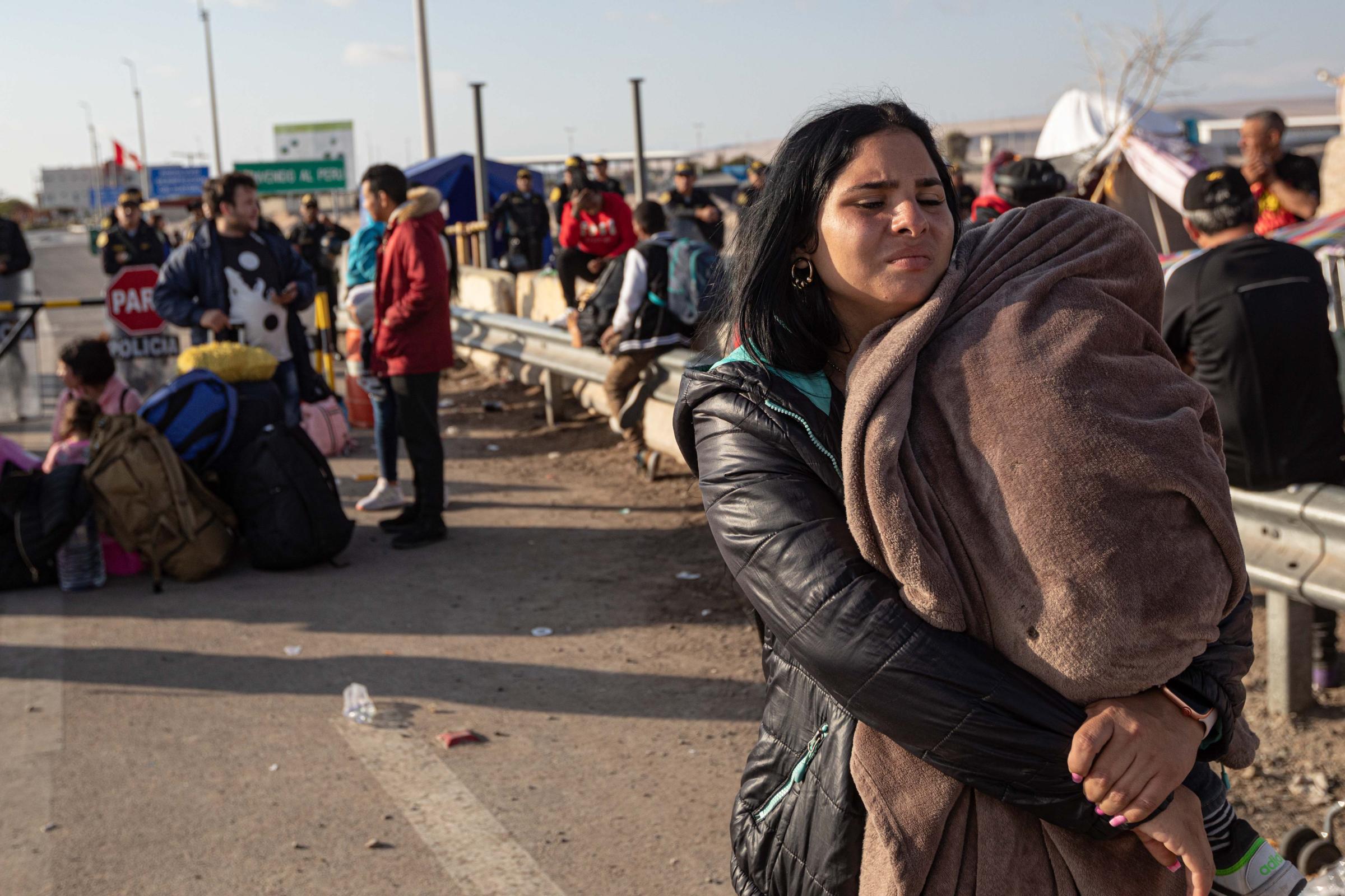 Fear, cold and xenophobia: broken dreams on the Chilean border - A woman cries while carrying her son, after being refused entry to Peru, on Wednesday, May 3....