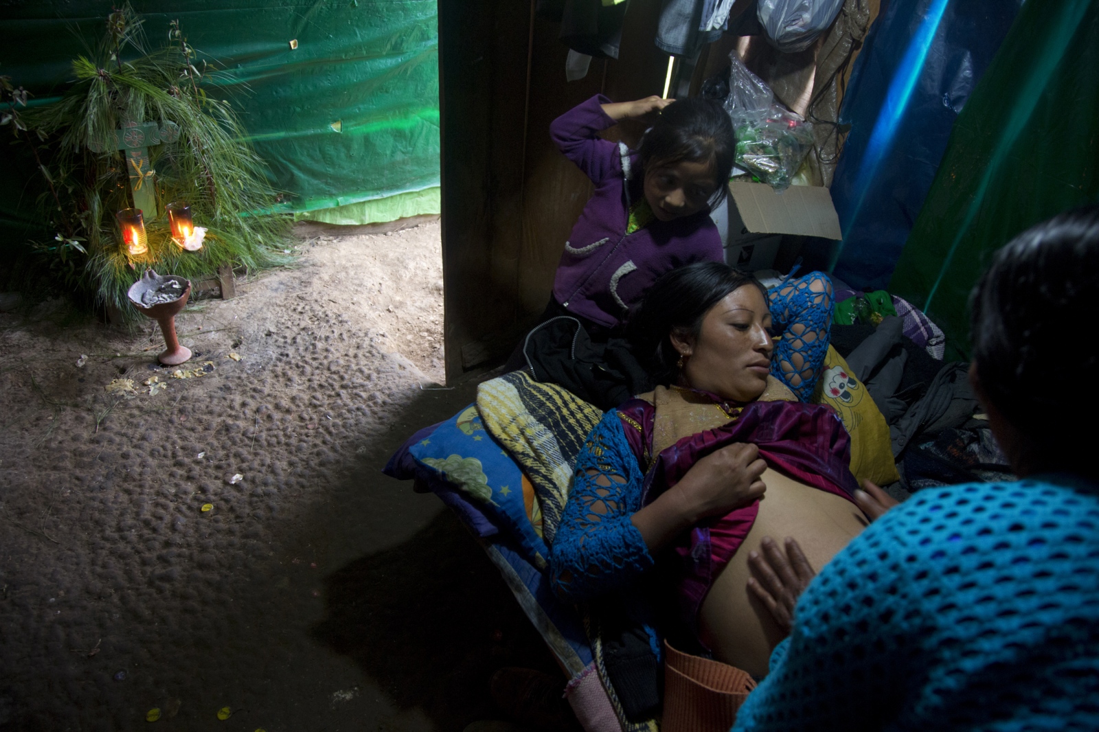  In the Highlands of Chiapas, Mexico, traditional midwife MarÃ­a LÃ³pez Gonzalez (known as â€œDoÃ±a Mariâ€), checks the abdomen of her patient...