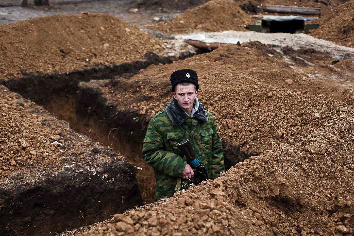 December 2014. Luhansk. Ukraine. A young Cossack soldier of pro-Russian separatist forces stands attentively in a trench near the town of Pervomaisk.