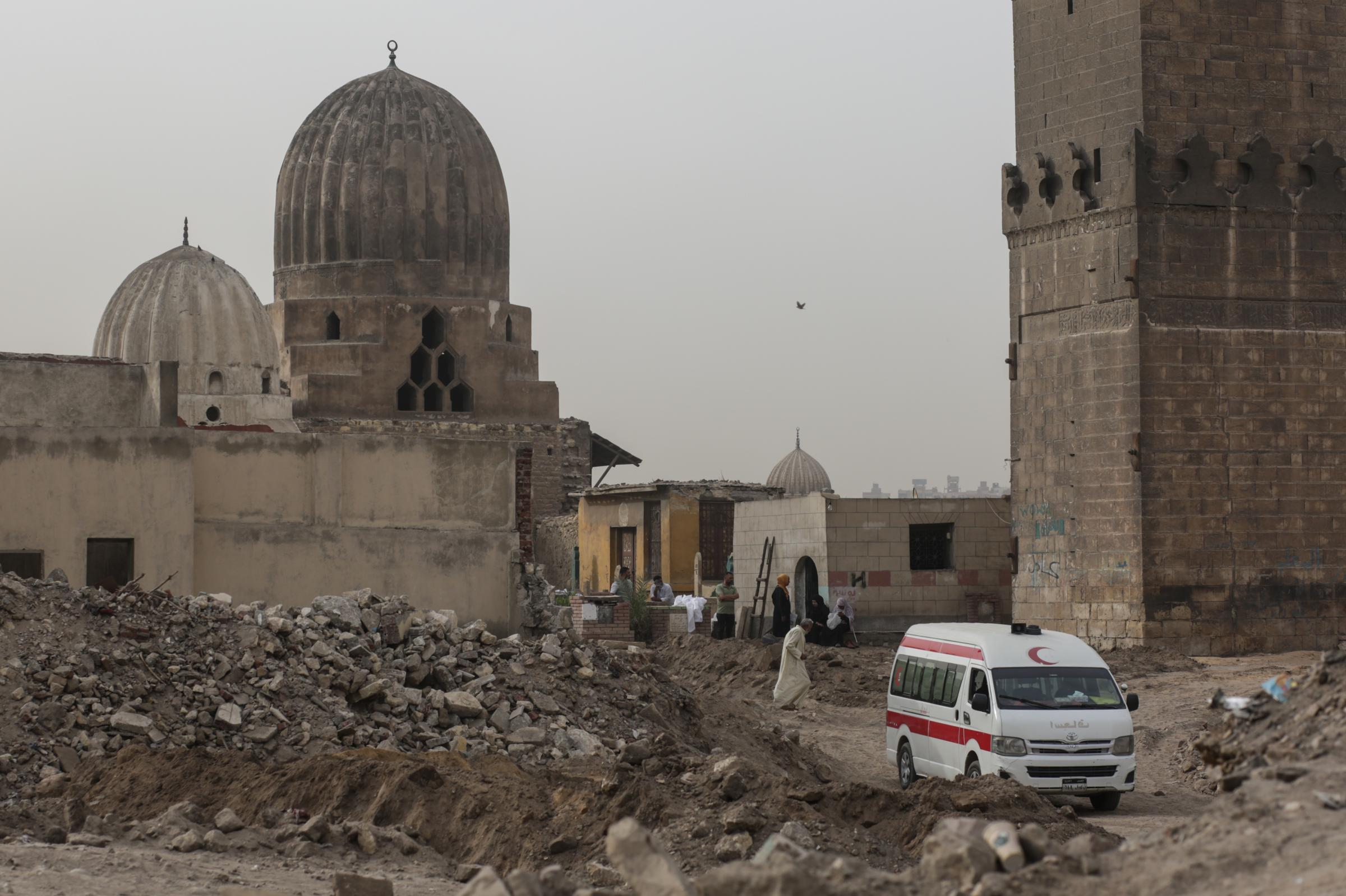 Bulldozers tear into Cairo's historic Islamic cemeteries - A family carries in an ambulance the exhumed remains of...