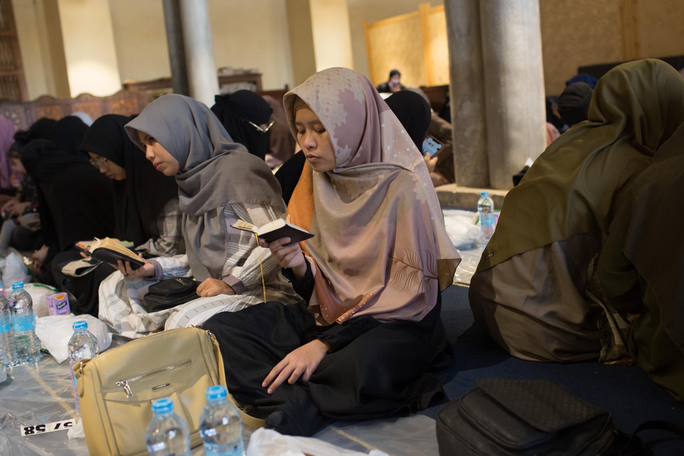Ramadan in Cairo - Muslim women read Quraan after performing evening prayers...