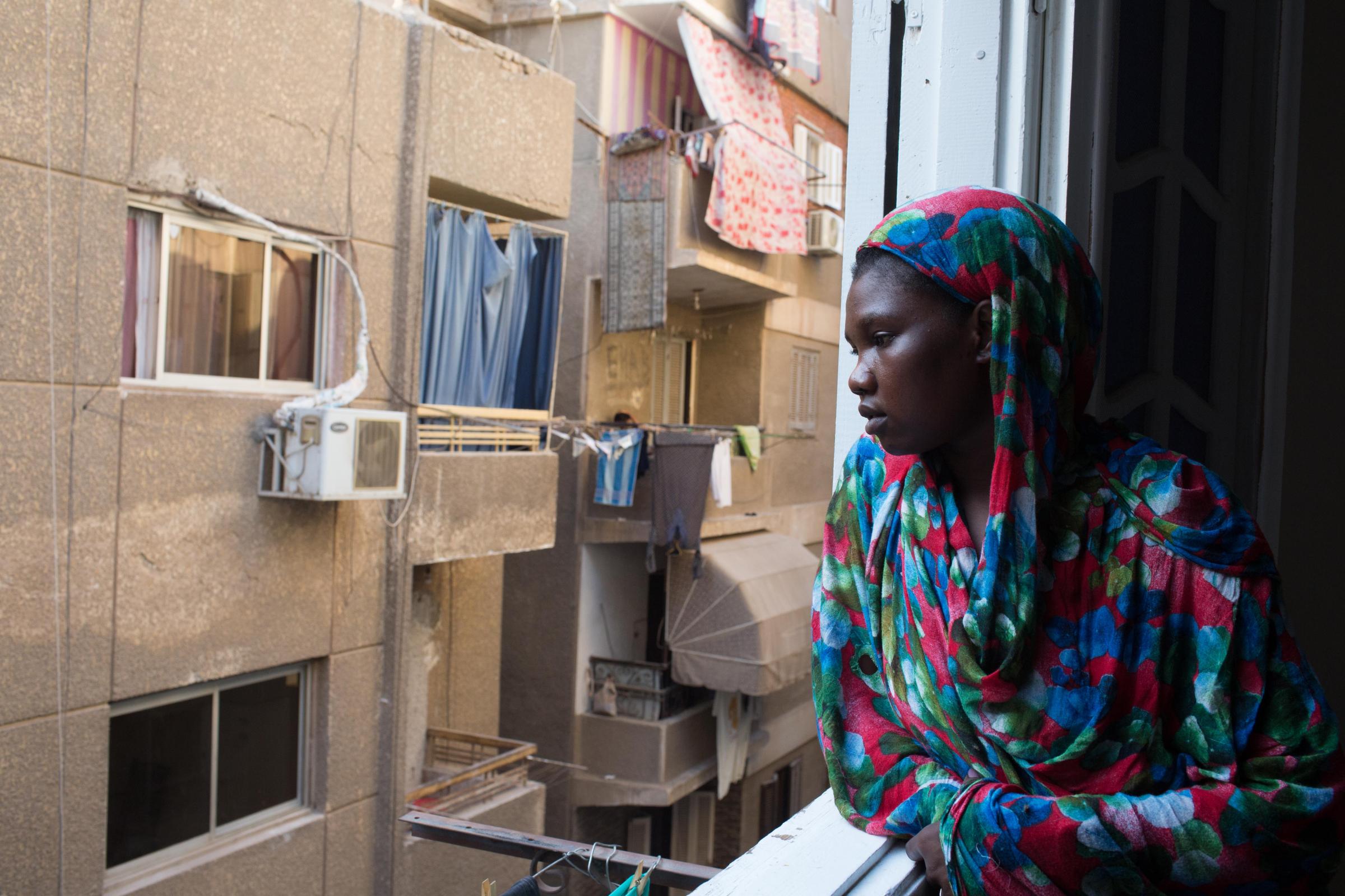 Sudanese head north to Egypt seeking brighter future - Abukk Sebit, 25, looks from her balcony after working to...