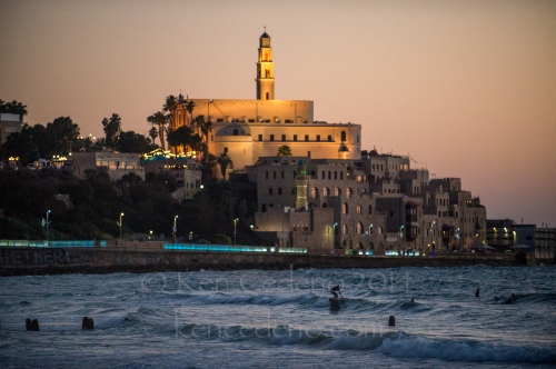 Image from ISRAEL -                 A man surfs toward the beach in Old Jaffa...