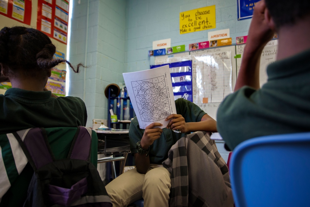 Students go over homework together in math class. Their teacher asks the answers to the questions and the students are asked to quietly raise their hands to respond. However, the rambunctious young kids often yell out the answers in excitement.