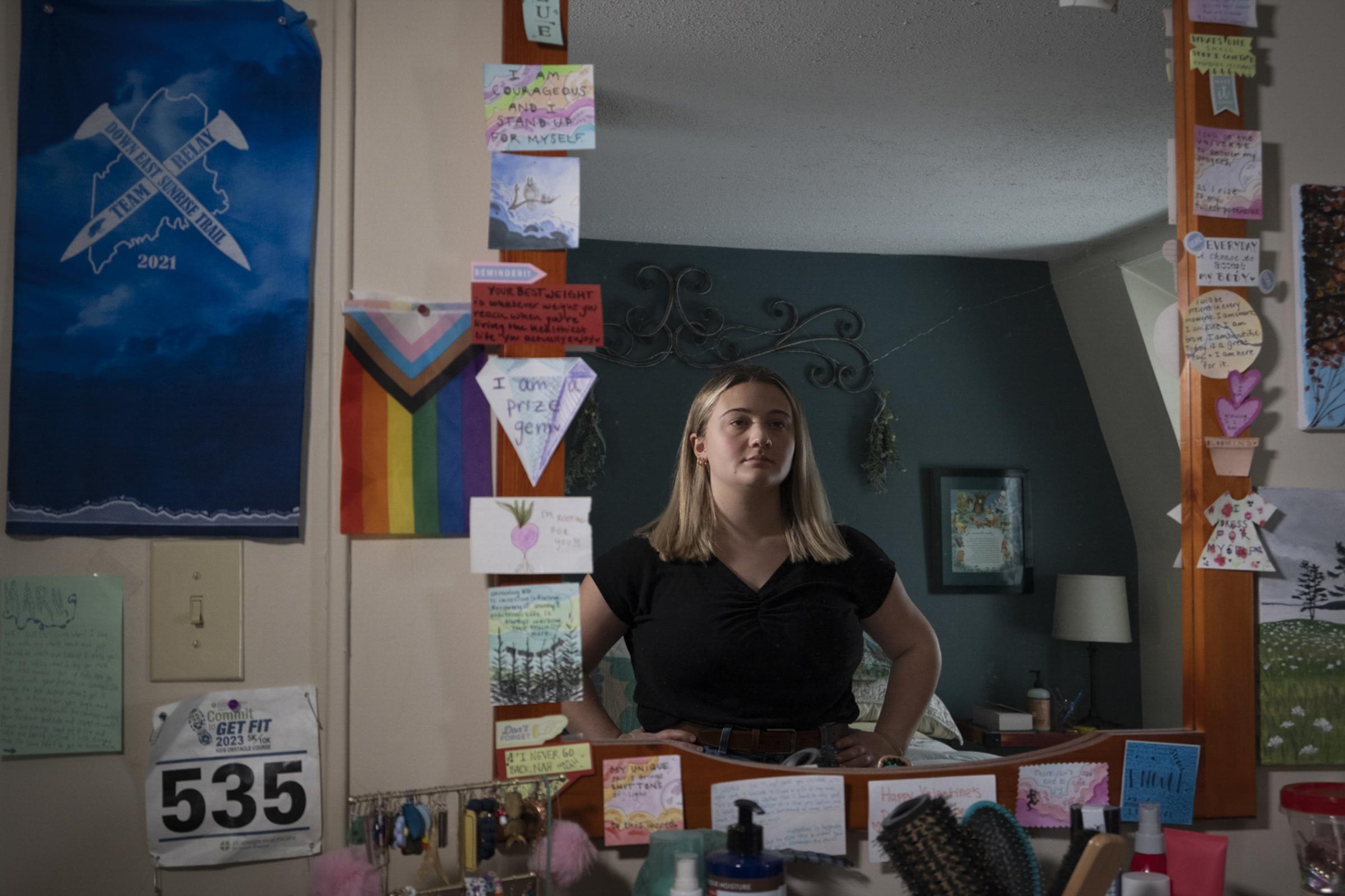 Mary Richardson, a former college athlete who recovered from an eating disorder, looks in her bedroom mirror in Bangor, Maine on January 20, 2024....