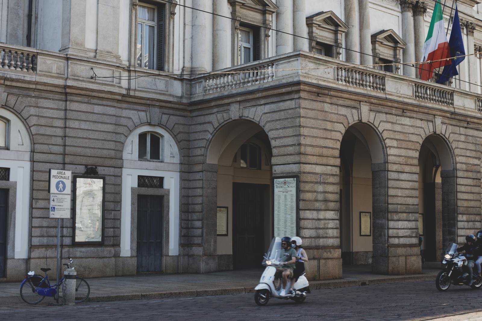 People passing in front of La Scala on a Vespa | Buy this image