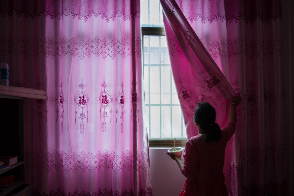 The Price of Happiness [stills] - Buntha opens a curtain to let some light into the room in...