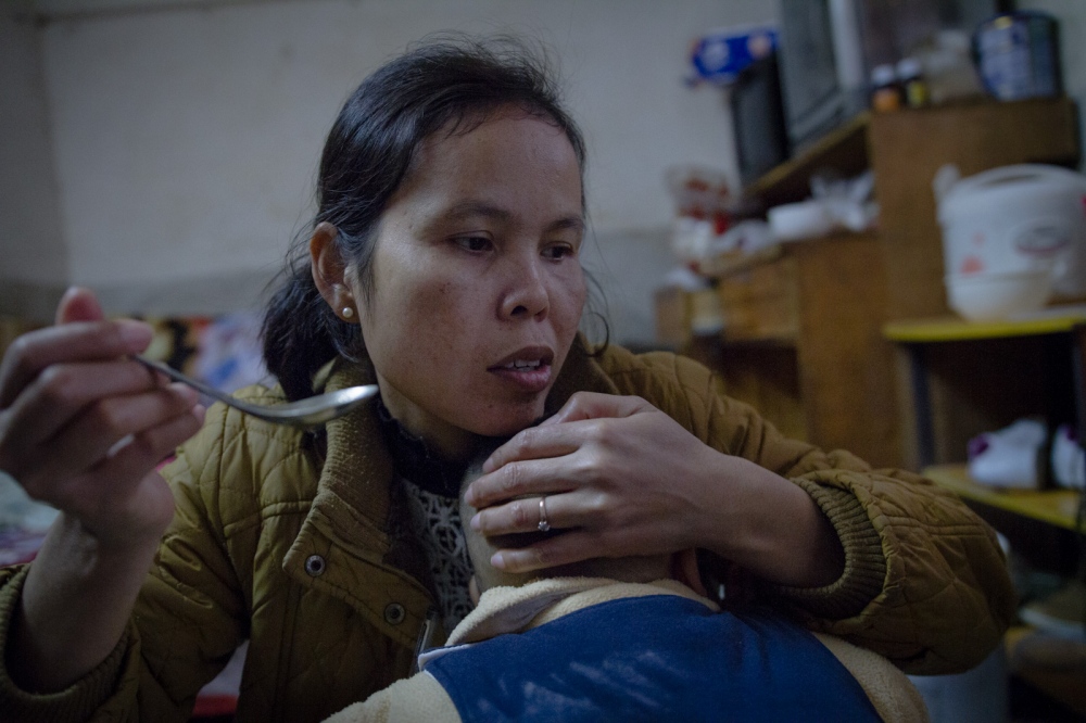 The Price of Happiness [stills] - Buntha feeds her son at home, January 2016.    
