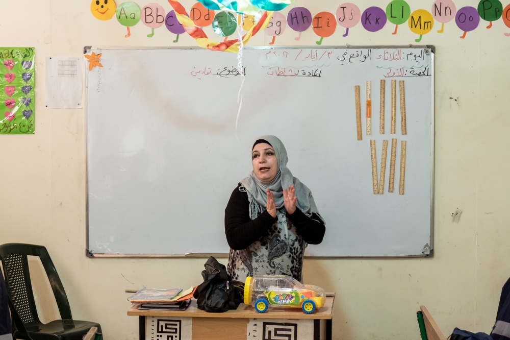A Syrian teacher is giving a le... quality learning environment. 
