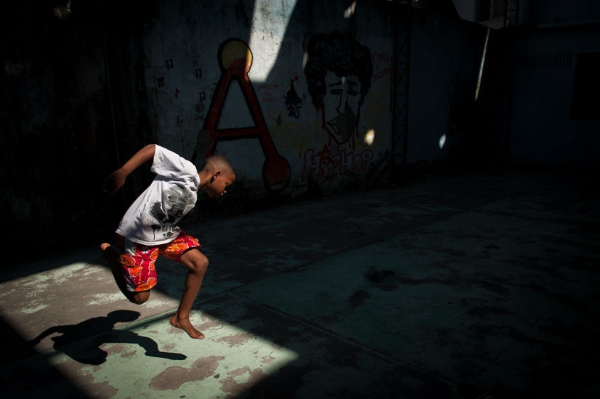      In this Aug. 3, 2013 photo, a boy jumps in the air and grabs his foot while practicing a step from a dance form called "passinho," or "little step," at a makeshift dance studio in the Borel favela, in Rio de Janeiro, Brazil. Passinho is a mix of samba-esque footwork, breakdance handstands, free spins and athletic acrobatics, all set to a music heavy on funk hooks laid over snare beats.     