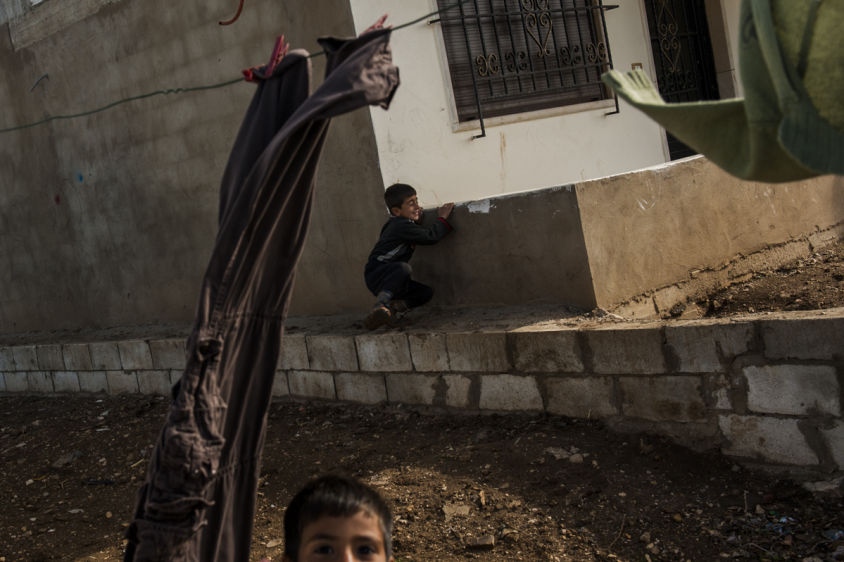     Two children, Syrian refugees, play behind an abandoned building in The Bekaa Valley, Lebanon on March 10, 2014.     