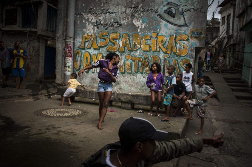  In this Aug. 17, 2013 photo, Marcelly de Mello da Silva, 15, shows off her "passinho," or "little step," moves to a young audience gathered in the Borel favela, in Rio de Janeiro, Brazil. Passinho is a free-form style of dance that is catching on with young people all over the city. The dance borrows from various influences, including samba movements, break dance handstands, and is set to pounding beats on top of soulful hooks. Although Passinho has been around for years, it only recently gained momentum after the baile funk, preferred by drug traffickers, started disappearing during the pacification of the slums. 