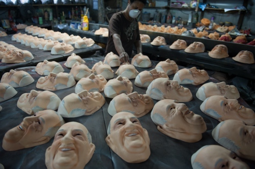    Olga Valles arranges Pope Francis masks as they dry at her family's Condal mask-making factory ahead of the pontiff's visit in Sao Goncalo near Rio de Janeiro, Brazil, Tuesday, July 9, 2013. The pope's July 22-29 visit to Brazil, the world's largest Roman Catholic country, will be his first foreign trip as pontiff.    