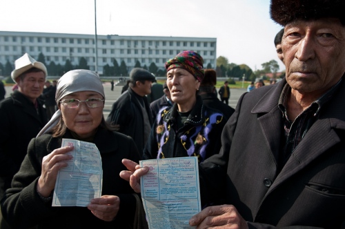     Protestors hold up work documents outside of a polling station in Osh, Kyrgyzstan. November, 2011.    