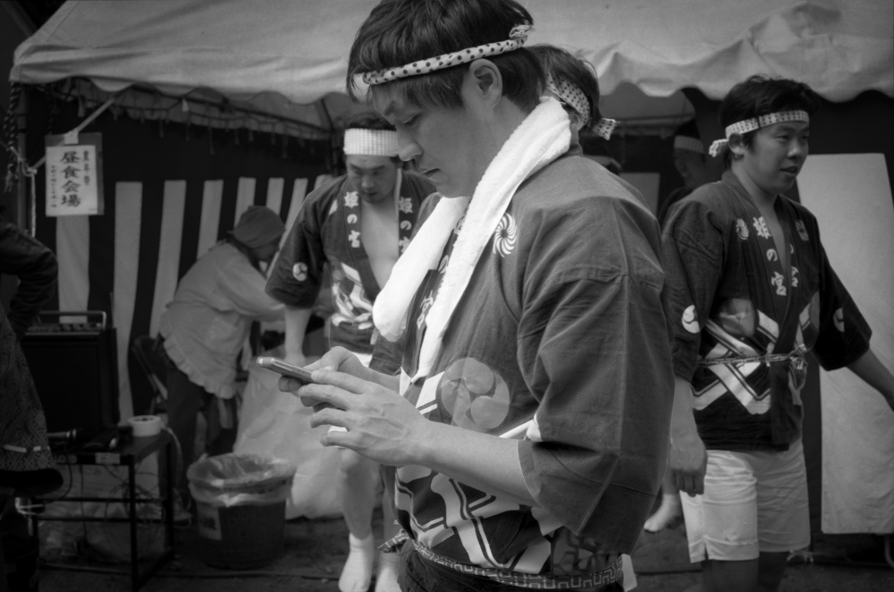 Man checks his phone at the Japanese Spring Festivals