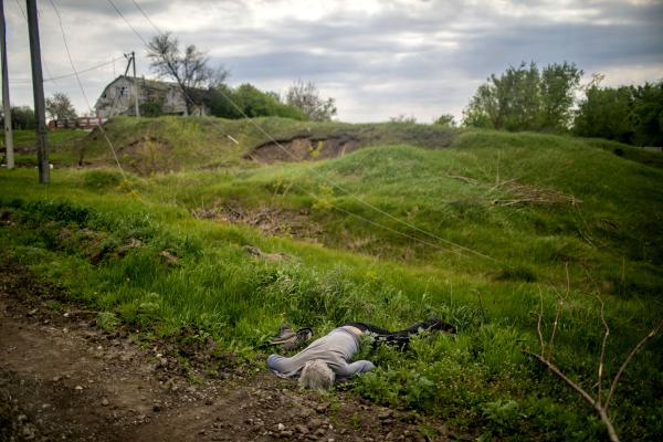 Image from Ukraine-Russia War - The body of a civilian lies on a road near the village of...