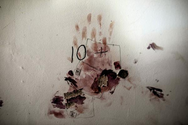 Image from The October 7th War - A handprint full of blood on a wall inside a house in...