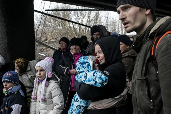 Residents of Irpin wait to be evacuated under a destroyed bridge that connects the city to Kyiv. Volunteers and Ukrainian army personnel help them cross the bridge and get to safety. Although Ukrainian forces were able to repel and destroy multiple forces invading Irpin it remained a dangerous battle zone for days.