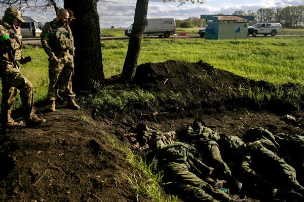  Ukrainian army soldiers looking at the bodies of 11 Russian soldiers in the village of Vilkhivka, recently liberated by Ukrainian forces near Kharkiv city. local residents said that around 60-70 people left the village with the retreating Russian army, as they didn&#39;t want to stay under Ukrainian rule. 