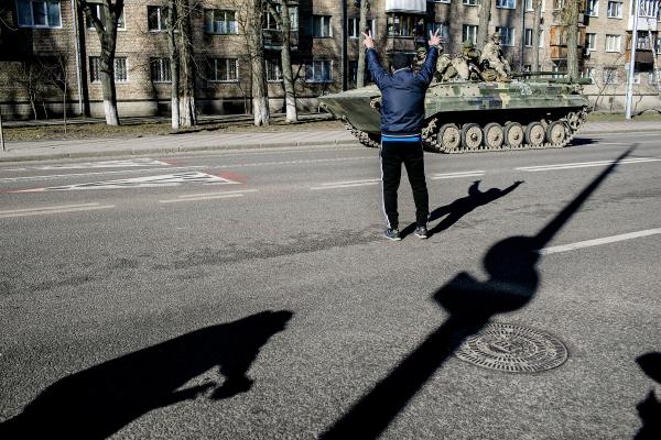  Residents wave as a Ukrainian army convoy crosses one of the main streets in the northern parts of Kyiv on the third day of the war. 