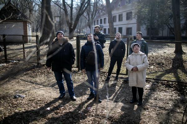 Local residents of Kyiv watching towards a building that was heavily damaged by a Russian rocket shot on the city&#39;s northern areas.