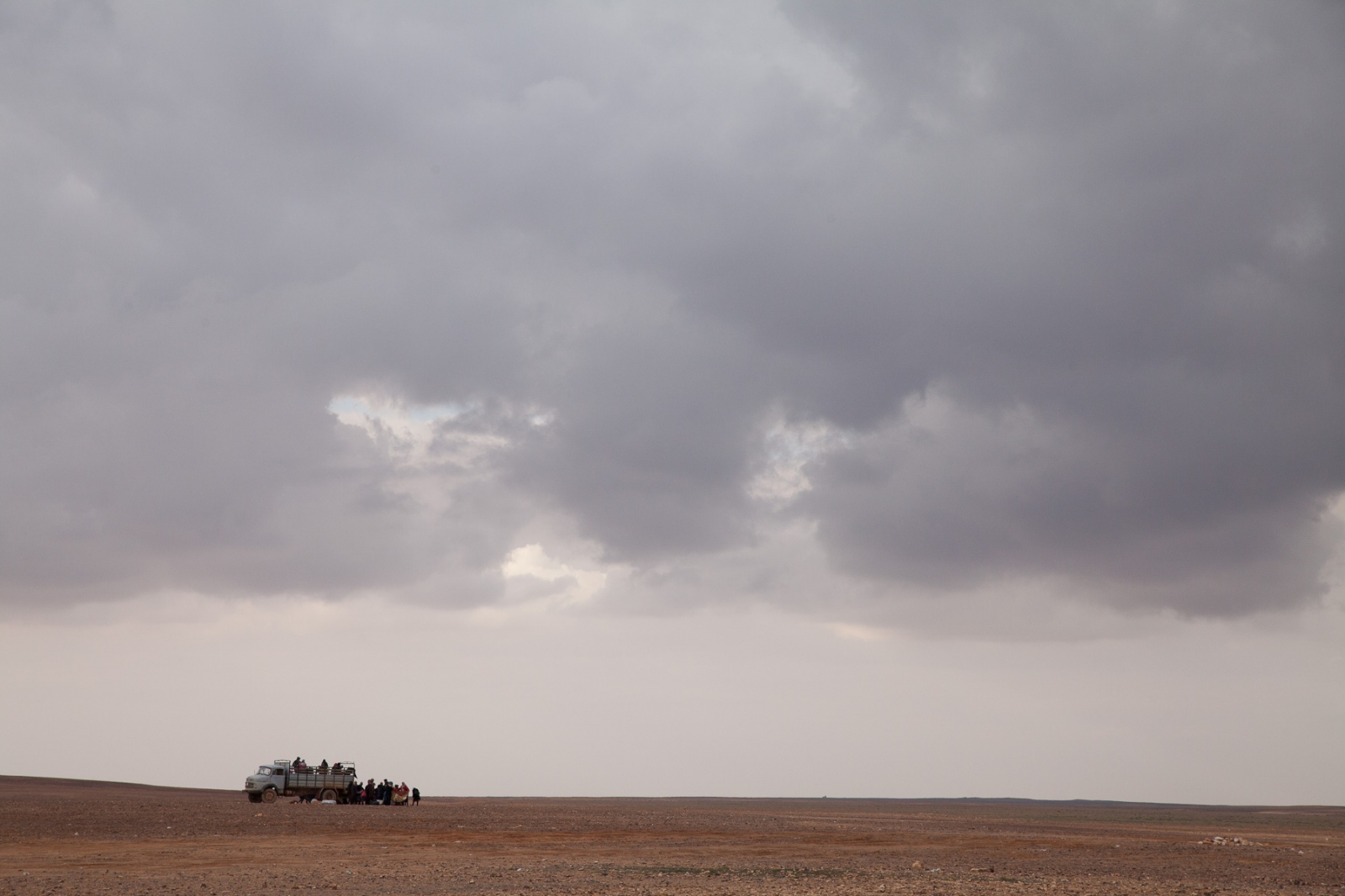 A group of refugees arrive on the Syrian side to a buffer zone several kilometers across dividing Jordan and Syria.
