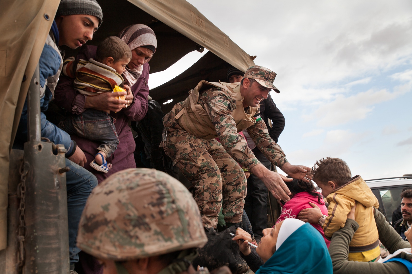 The Syrian Refugee Crisis - Jordanian troops and UNHCR members provide the refugees...