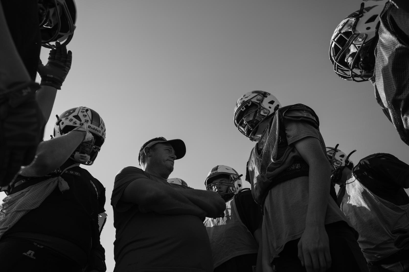 Kind Words, Big Differences - Williamsburg football coach Vaughn Hatcher, center left, huddles with a group of his players at...