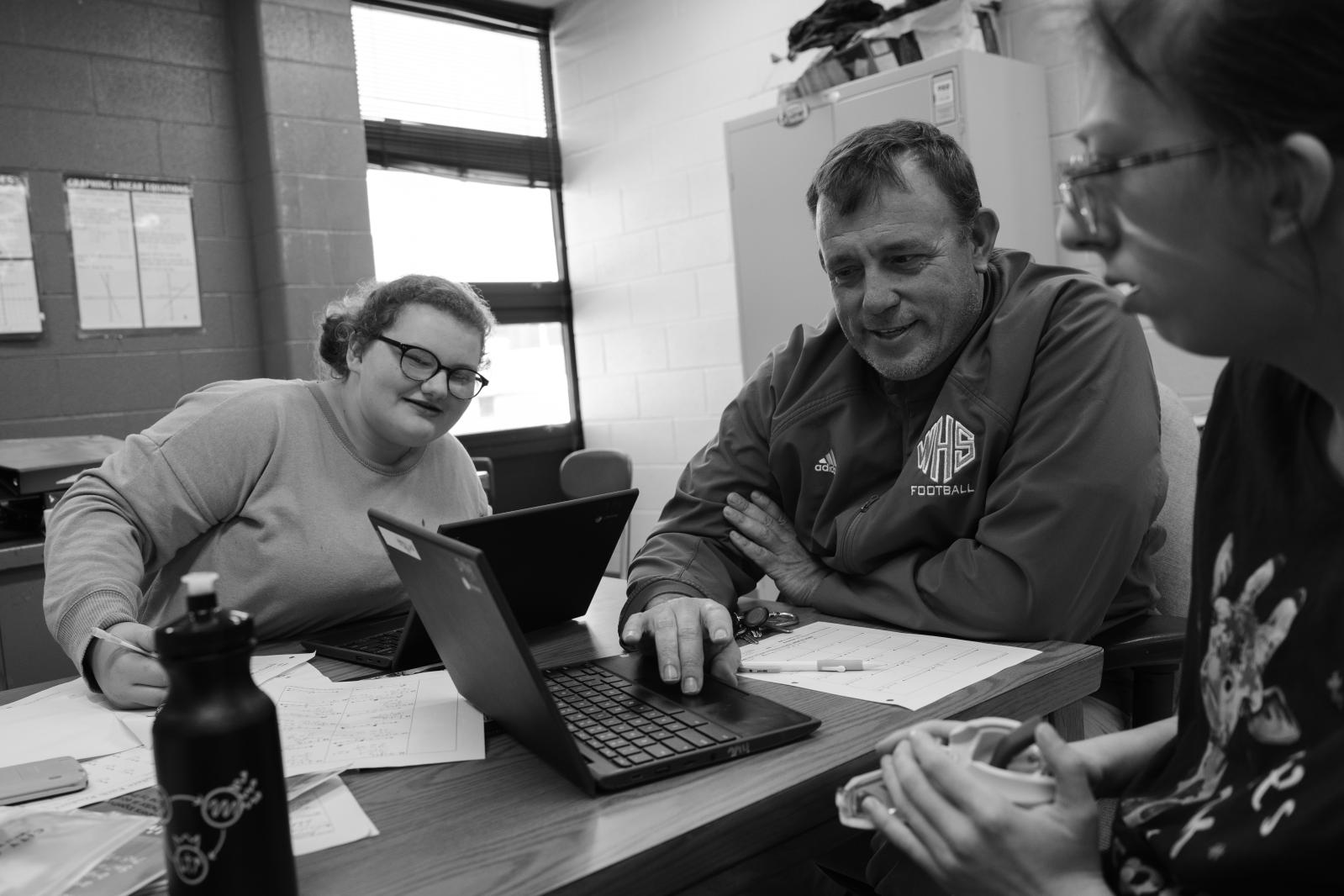 Kind Words, Big Differences - Freshmen Alivia Mills, 15, left, and Emily Craft, 15, right, listen as Vaughn tutors them through...