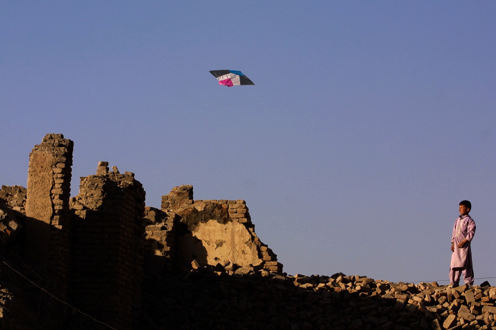 Onward to Kabul - A young boy looks skyward while flying his kite. At that...